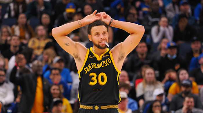 Golden State Warriors guard Steph Curry holds his hands over his head during a game.